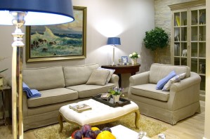 Ferienwohnung Zauberhaft - Einblick ins Wohnzimmer mit englischer Einrichtung, Sofa, Sessel, Tischleuchten und Bücherregal